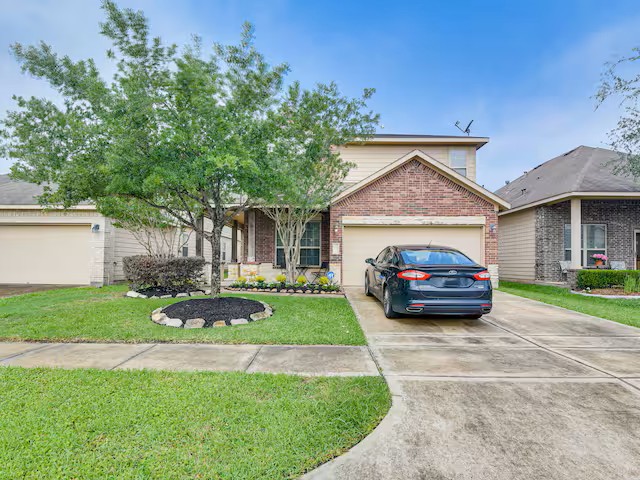 Gambar rumah suburban yang nyaman dengan halaman hijau.