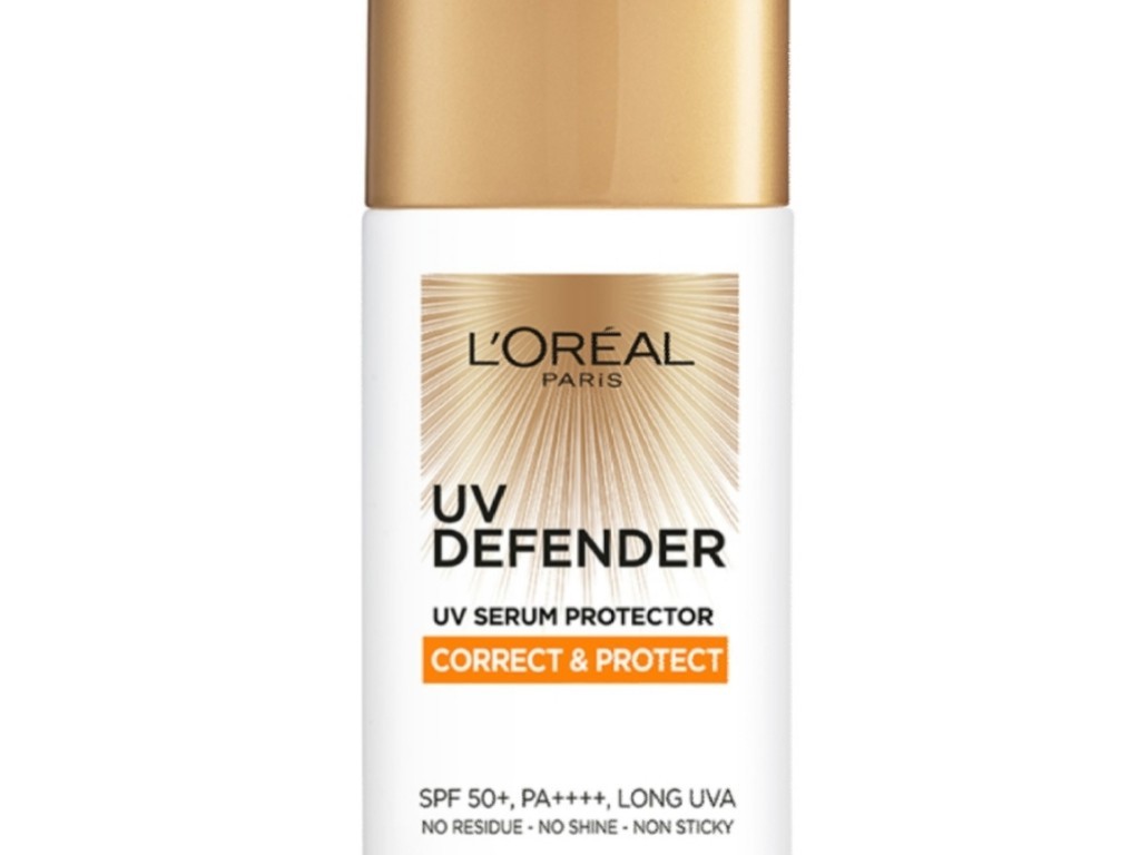 Gambar botol L'Oréal Paris UV Defender Serum Protector Sunscreen Spray dengan kabut halus yang keluar darinya, melambangkan aplikasi semprotannya, dengan latar belakang cerah dan aktif, dengan la