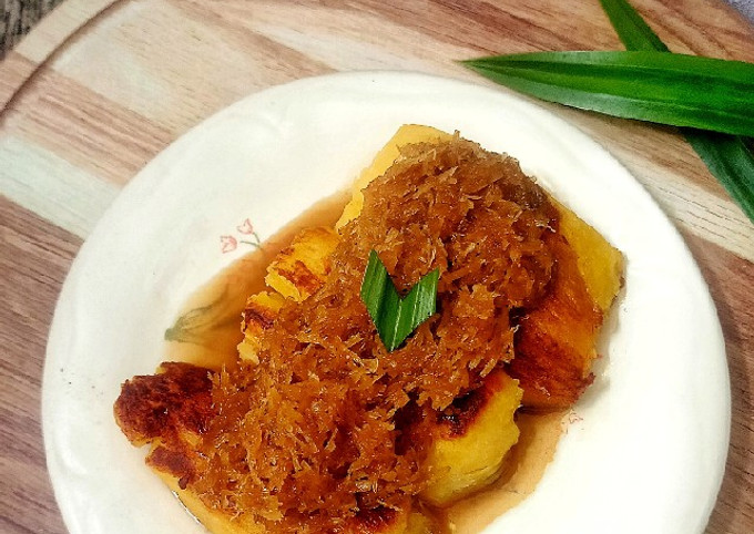 Seporsi colenak dengan peuyeum bakar dan saus gula merah kelapa di piring.