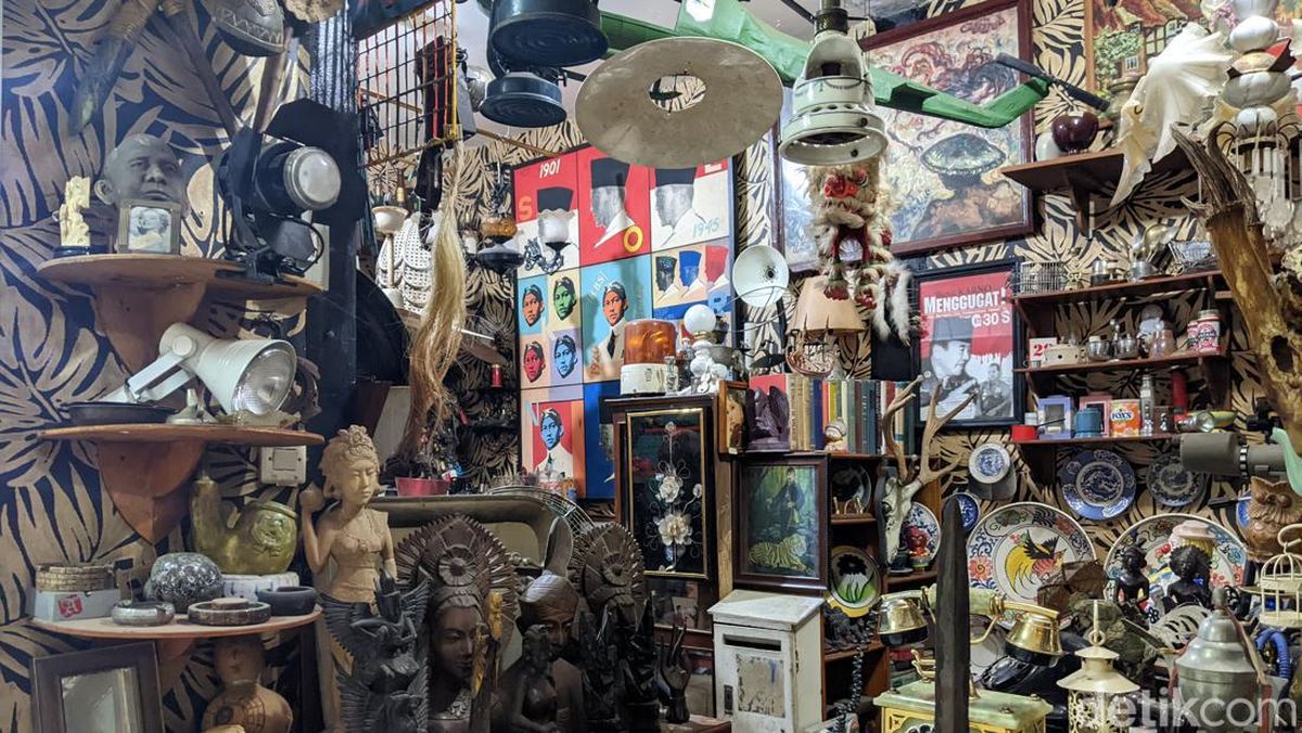 Penjual barang antik sedang menata koleksi barang jadul di Pasar Barang Antik Cikapundung.