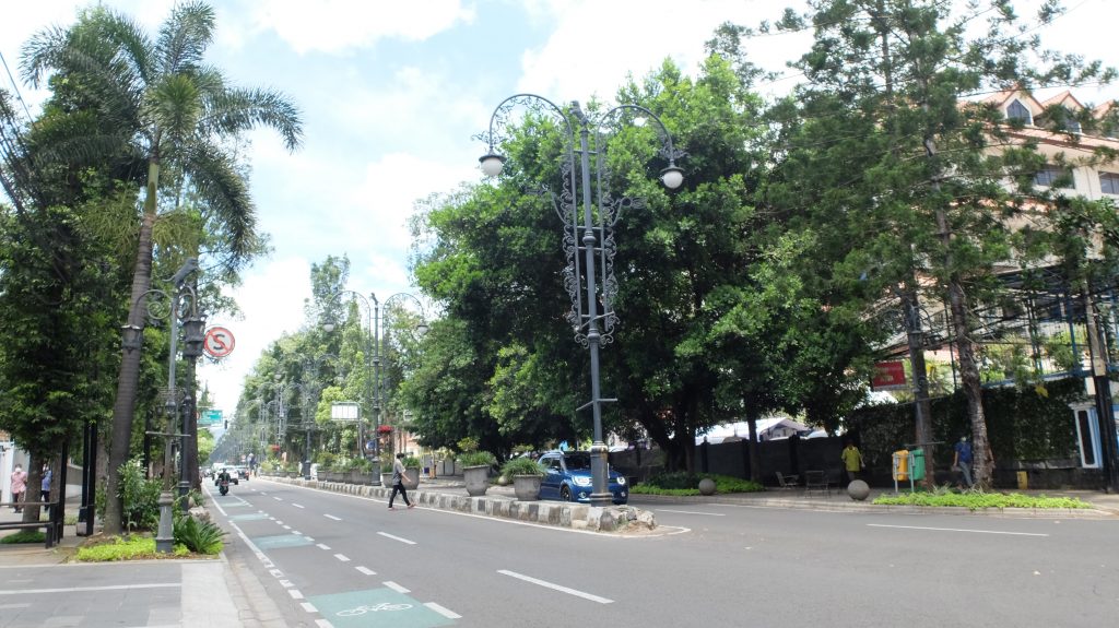 Gambar jalanan ramai di Coblong dengan mahasiswa dan kafe.