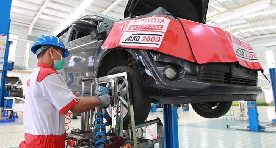 Mesin spooring balancing modern di bengkel ban dengan roda mobil yang sedang diperiksa.