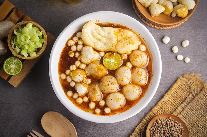 Semangkuk bakso aci komplit dengan kuah pedas dan topping pilus cikur.