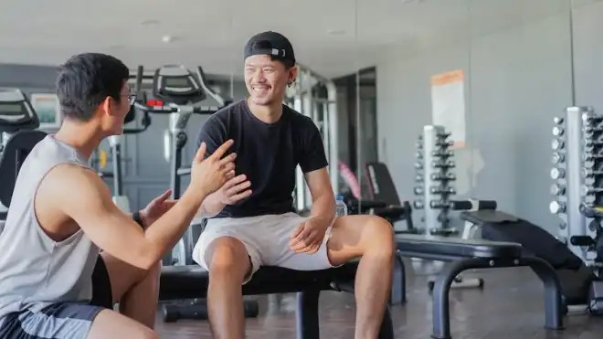  Personal trainer membimbing klien saat latihan di gym
