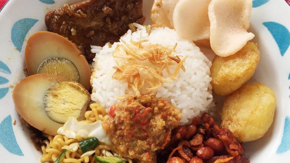 Sepiring nasi uduk Betawi dengan lauk pauk komplit.