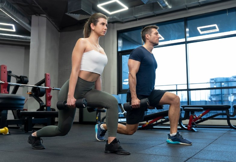 Personal trainer sedang membimbing klien melakukan latihan di gym, suasana fokus dan profesional.