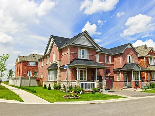 Gambar jalanan perumahan suburban yang rapi dengan rumah-rumah modern.