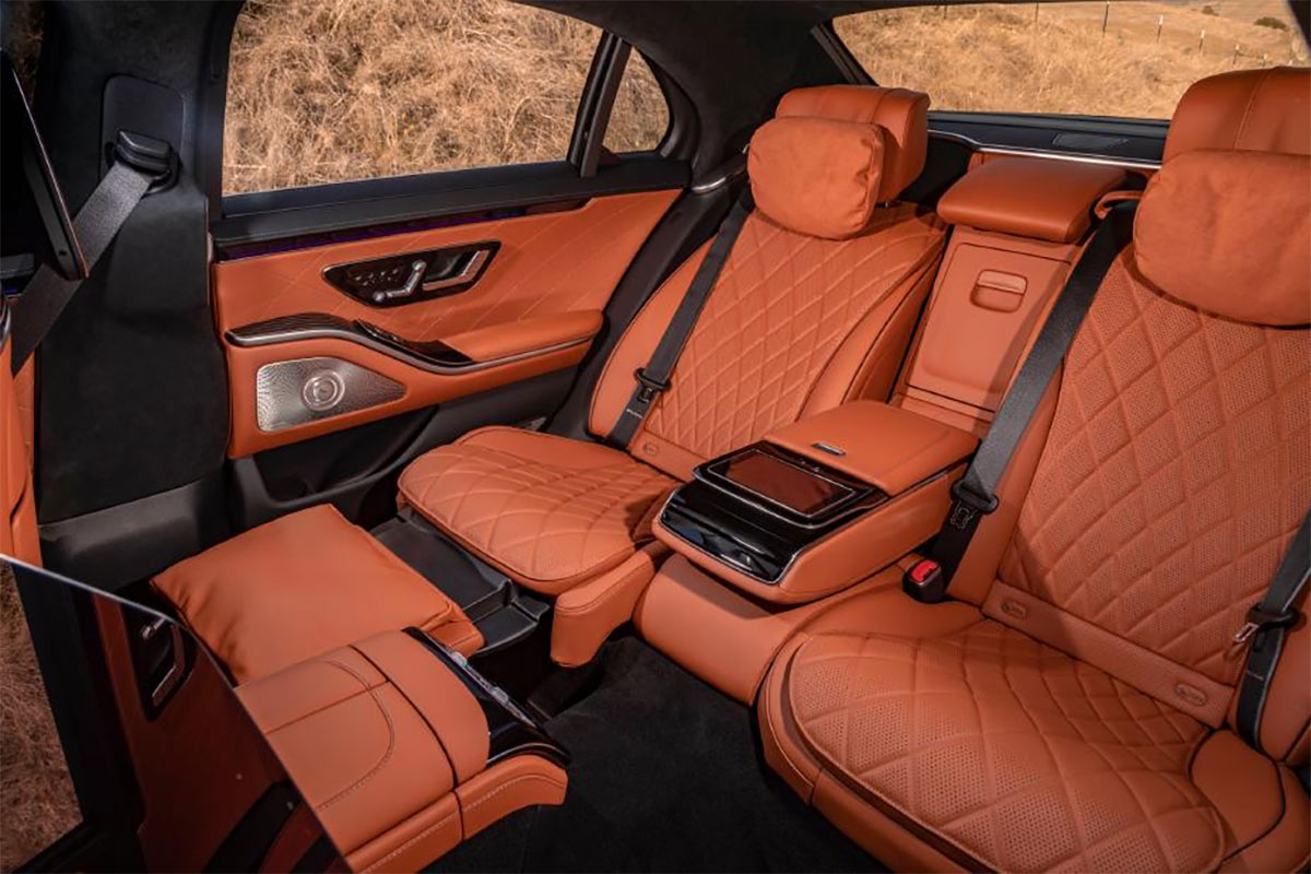 Interior mobil mewah dengan jok kulit yang bersih dan rapi, serta pencahayaan ambient yang hangat.