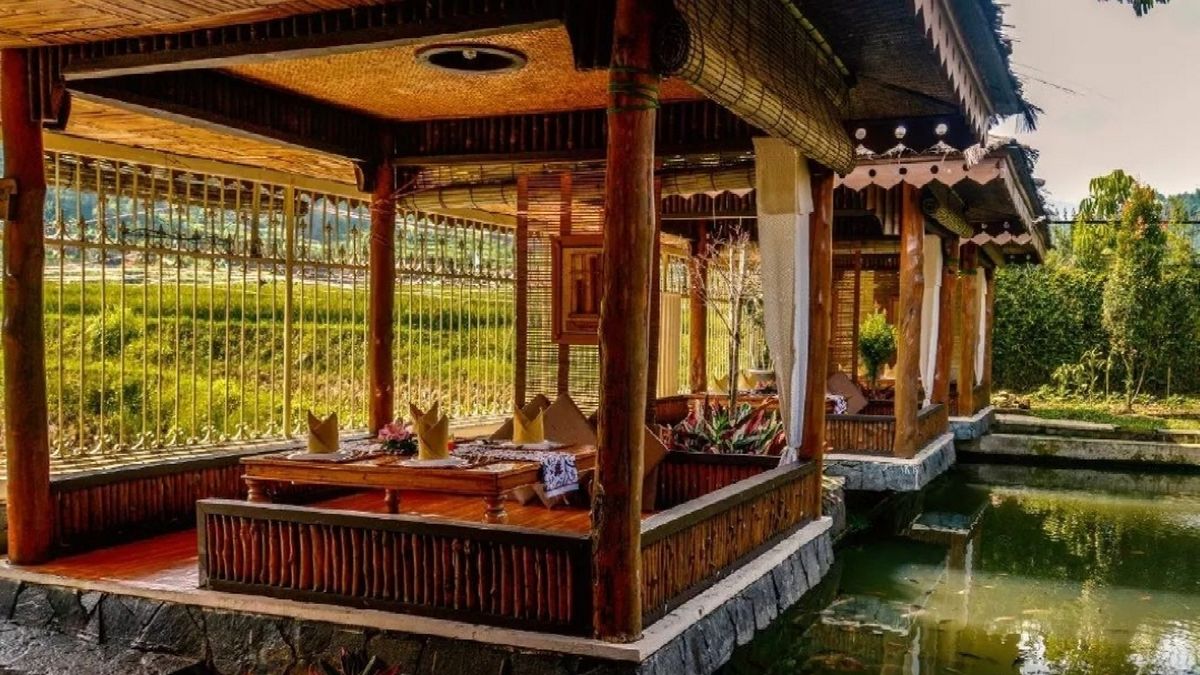 Suasana saung makan Sunda dengan kolam ikan dan gazebo yang asri.