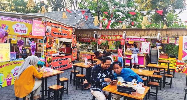 Suasana festival kuliner dengan berbagai tenant dan pengunjung yang ramai.