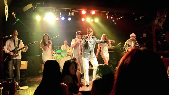 Panggung live music akustik di cafe dengan musisi sedang tampil dan penonton menikmati.