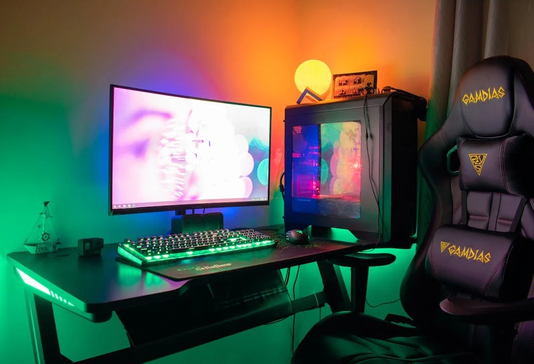 Interior warnet gaming modern dengan deretan PC dan kursi gaming, lampu RGB yang menyala.