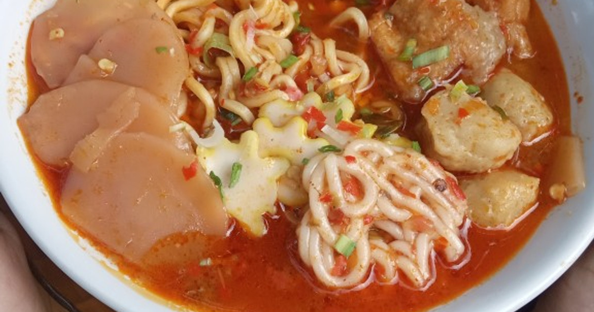 Semangkuk seblak ramen dengan mi ramen, kerupuk, dan topping bakso.
