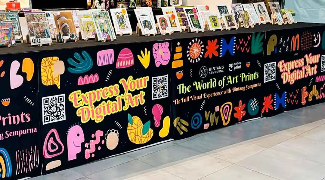 Sekelompok orang sedang berdiskusi di area cafe yang nyaman dengan poster event komunitas di dinding.