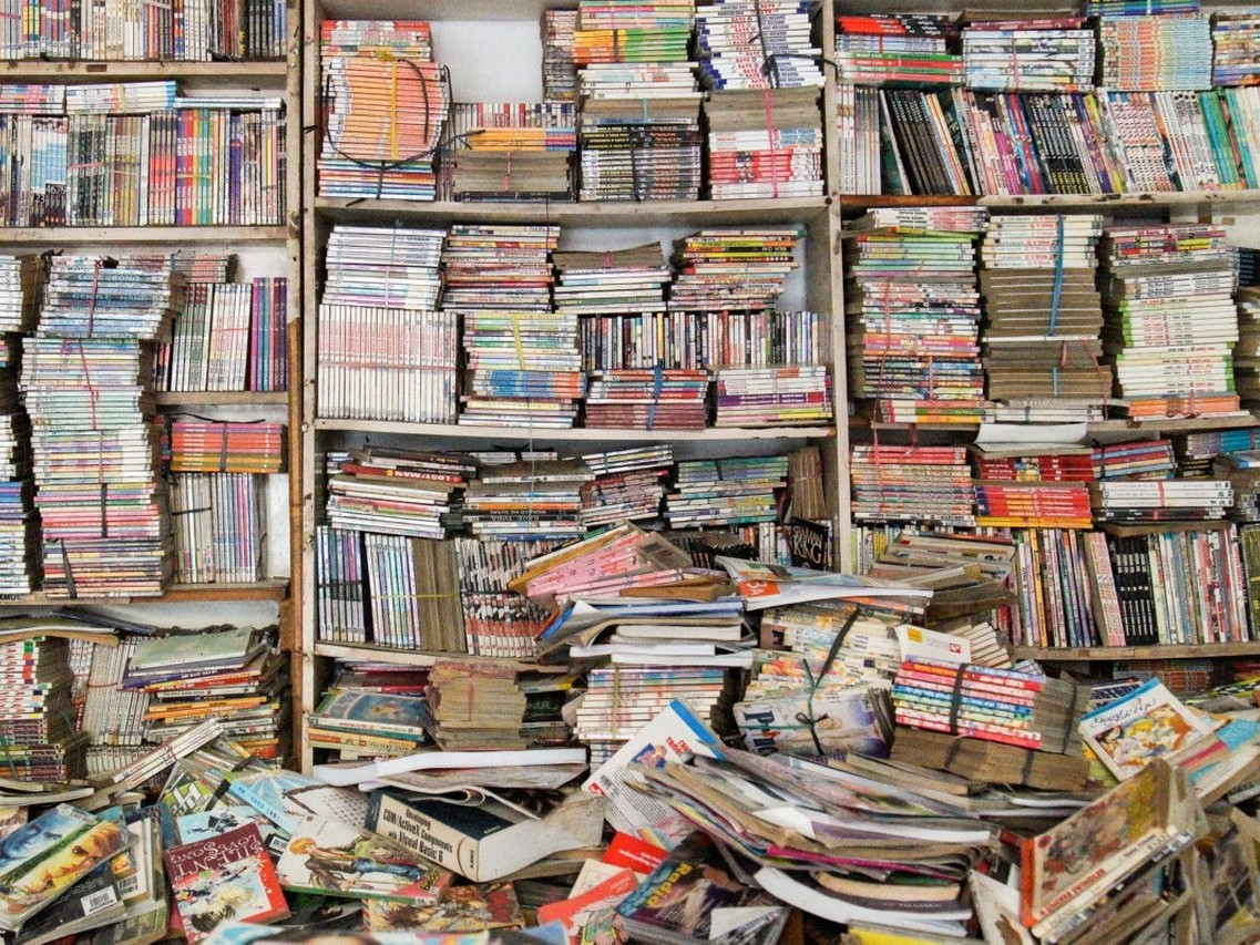 Gambar tumpukan buku bekas atau sudut nyaman di toko buku bekas.