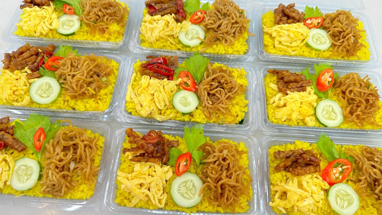 Nasi kuning bungkus dengan lauk pauk sederhana di tangan, siap disantap.