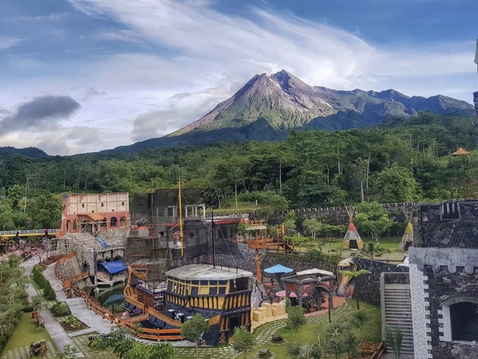 Gambar The Lost World Castle dengan arsitektur batu unik dan Gunung Merapi.