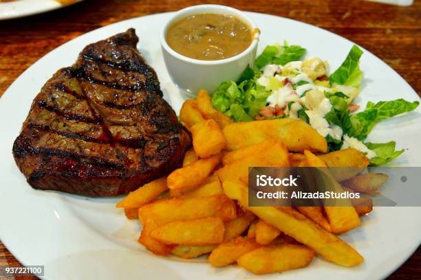 Piring berisi steak sirloin yang juicy dengan kentang goreng dan saus jamur.