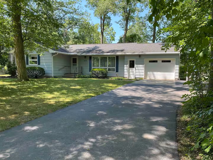 Gambar rumah suburban yang nyaman dengan halaman hijau.