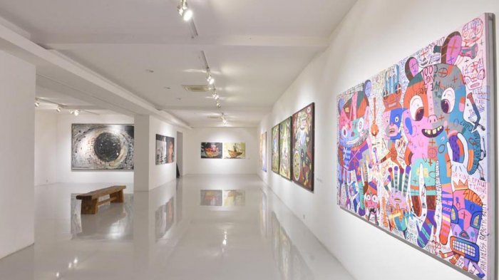 Interior galeri seni kontemporer dengan instalasi seni unik dan pencahayaan artistik.