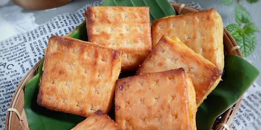 Gambar beberapa potong biskuit gabin goreng dengan isian manis di tengahnya, disajikan di piring.