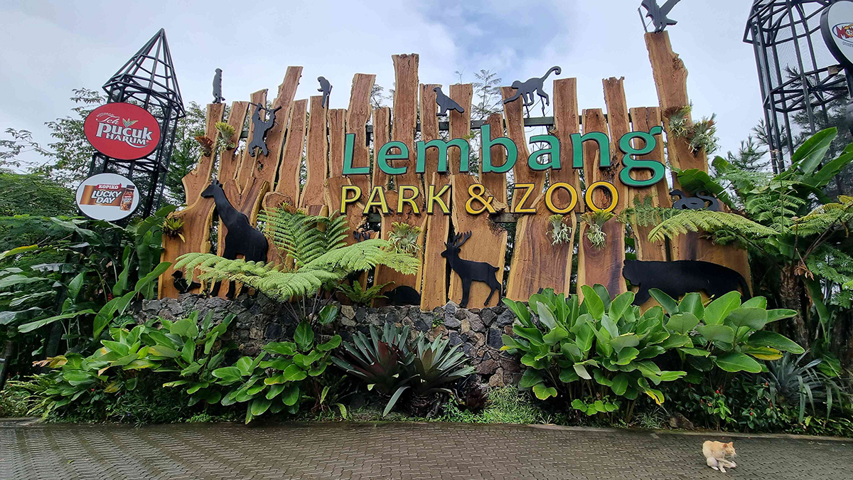 Keluarga berinteraksi dengan hewan di Lembang Park & Zoo dengan ceria.