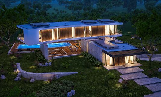 Gambar rumah modern di lereng bukit dengan pemandangan kota di malam hari.