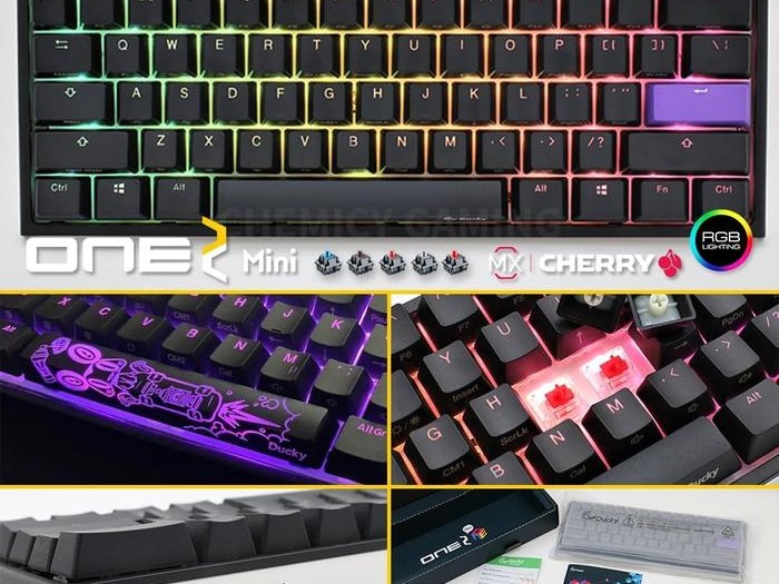 Gambar keyboard Ducky One 2 Mini di atas meja yang bersih dan ringkas, mungkin di samping mousepad gaming besar, menekankan ukurannya yang kecil dan nuansa premium.