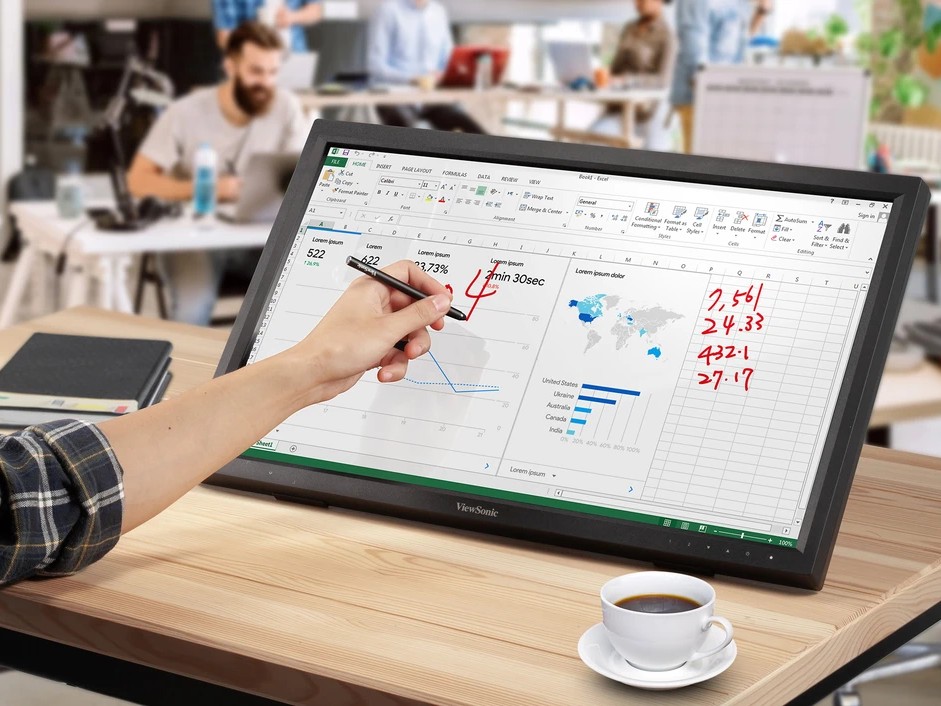 Gambar monitor sentuh ViewSonic TD series di atas meja, dengan tangan dua orang berinteraksi dengan bagian layar yang berbeda, mungkin membuat sketsa atau memberi anotasi pada dokumen, menekankan sifa