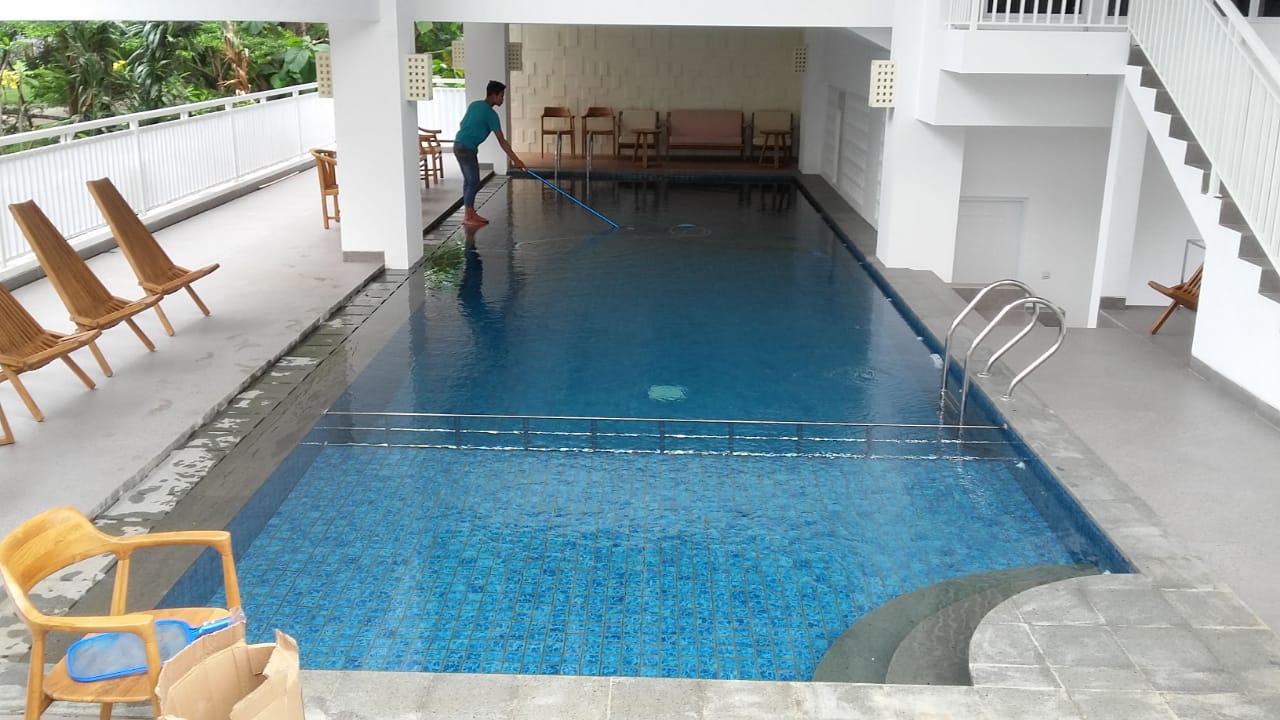 Kolam renang indoor yang bersih di dalam sebuah gym, dengan jalur berenang yang jelas.