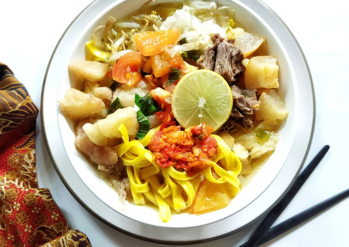 Semangkuk mie kocok dengan mie kuning, kikil, tauge, dan kuah kental kekuningan.