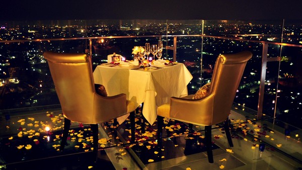 Fasad The Trans Luxury Hotel Bandung di malam hari dengan lampu-lampu menyala.