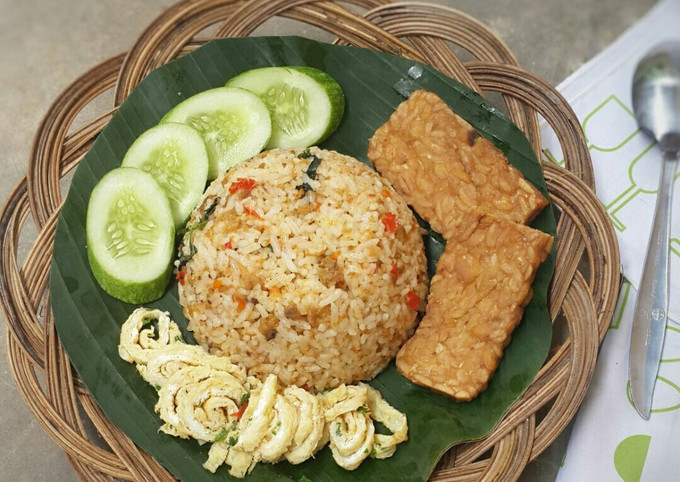 Sepiring nasi tutug oncom dengan irisan timun dan kerupuk.