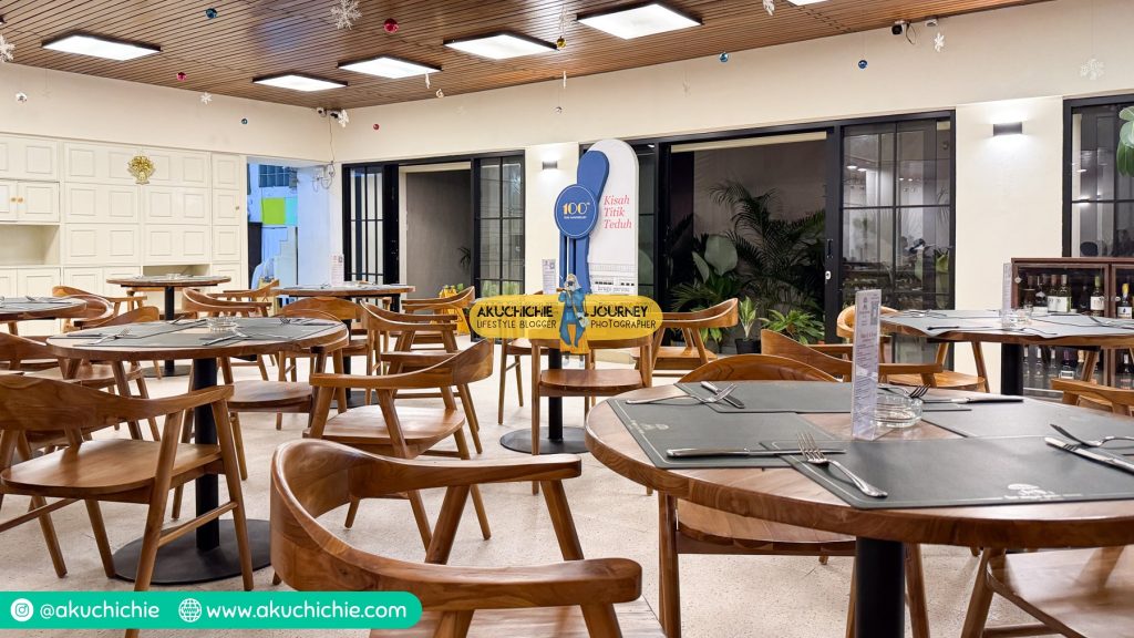 Interior klasik restoran Braga Permai dengan meja dan kursi kayu.