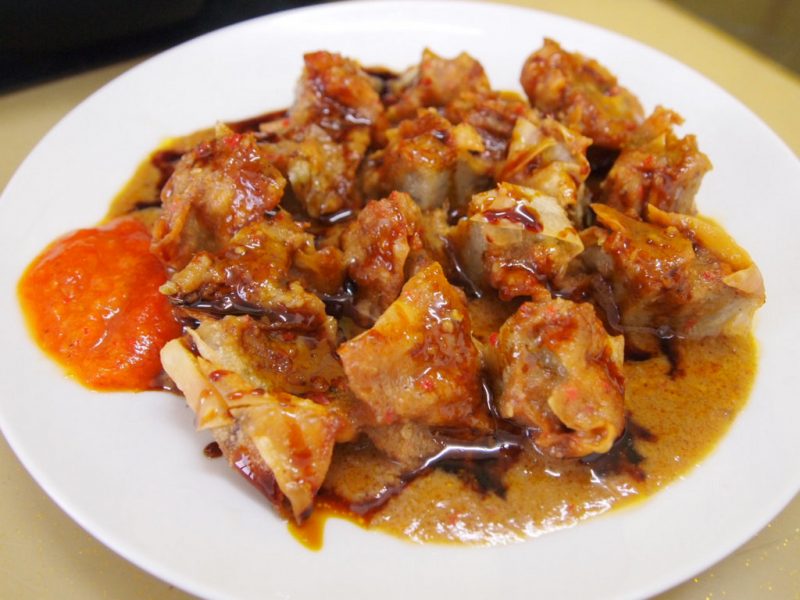 Beberapa potong batagor tahu disajikan dengan siraman bumbu kacang.