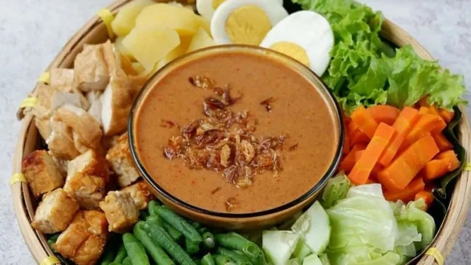 Sepiring gado-gado dengan bumbu kacang melimpah.
