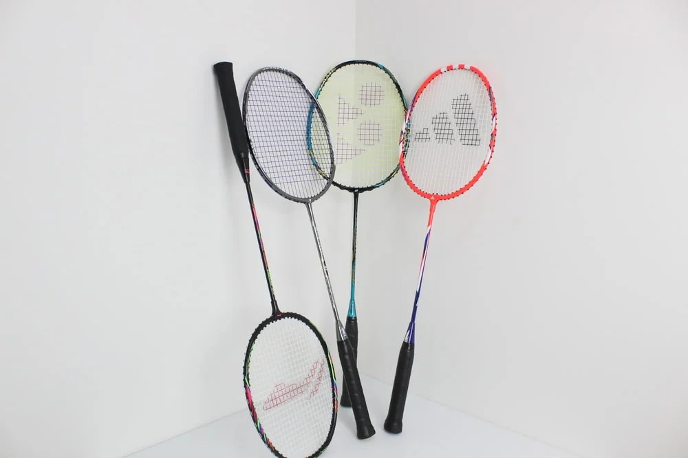 Raket badminton dengan tampilan seimbang, tidak terlalu tebal atau terlalu tipis, menunjukkan fleksibilitas.
