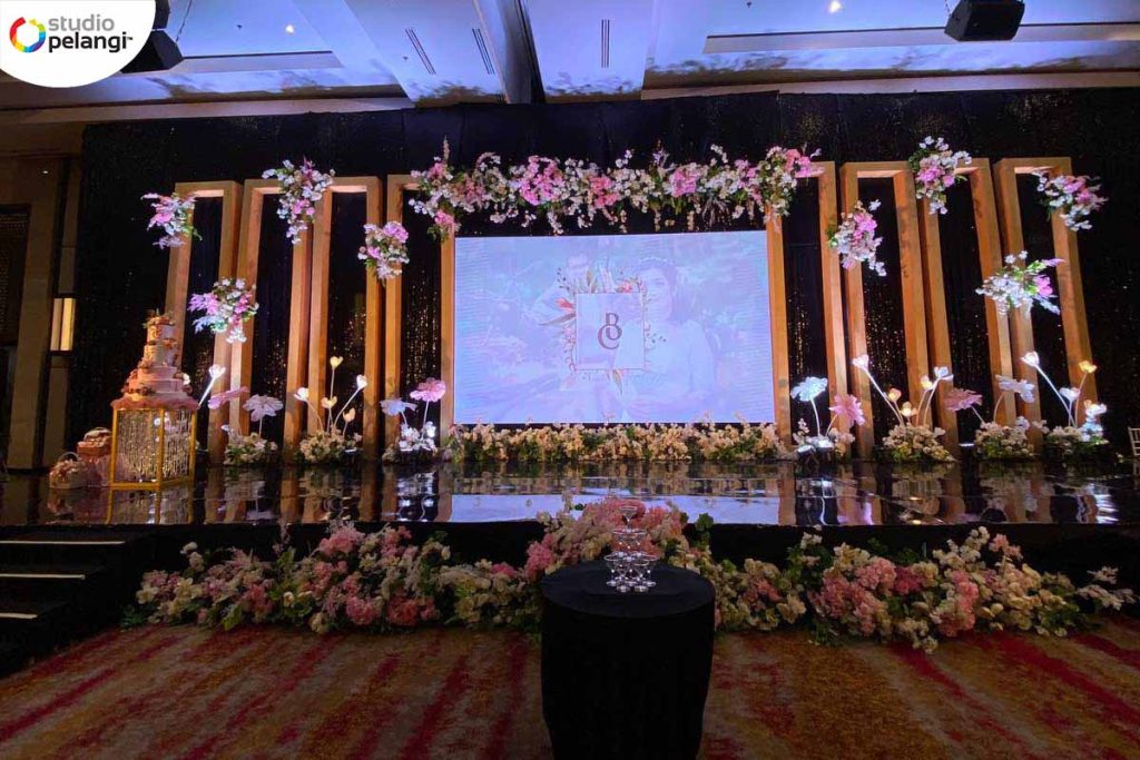 Panggung pernikahan dengan dekorasi bunga dan lighting romantis yang mewah.