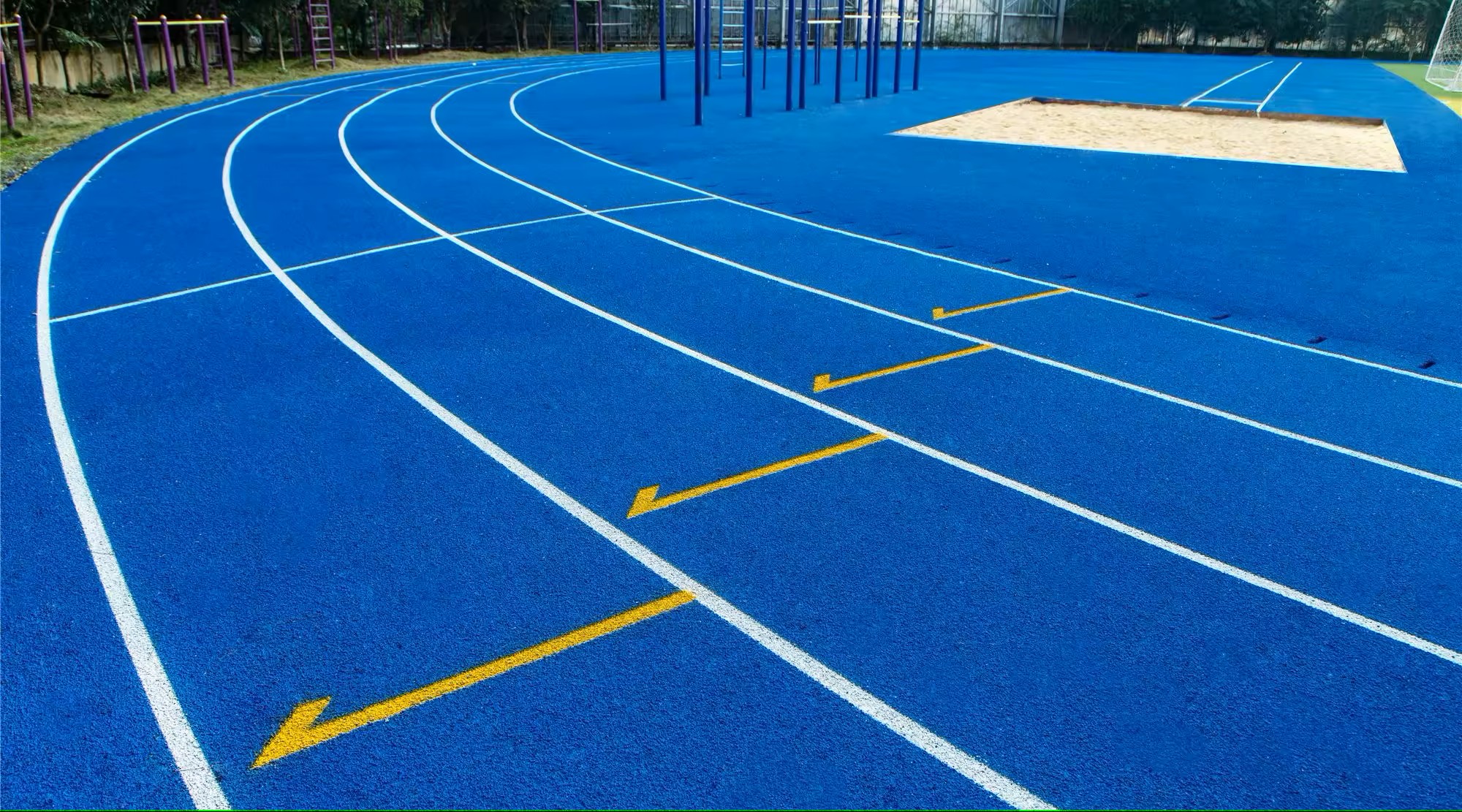  Lintasan atletik berwarna biru dengan marka lari