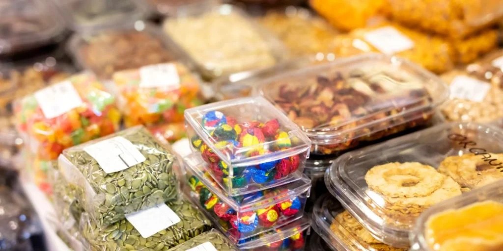 Gambar berbagai snack kemasan modern dengan desain warna-warni yang menarik, beberapa menunjukkan varian rasa unik.