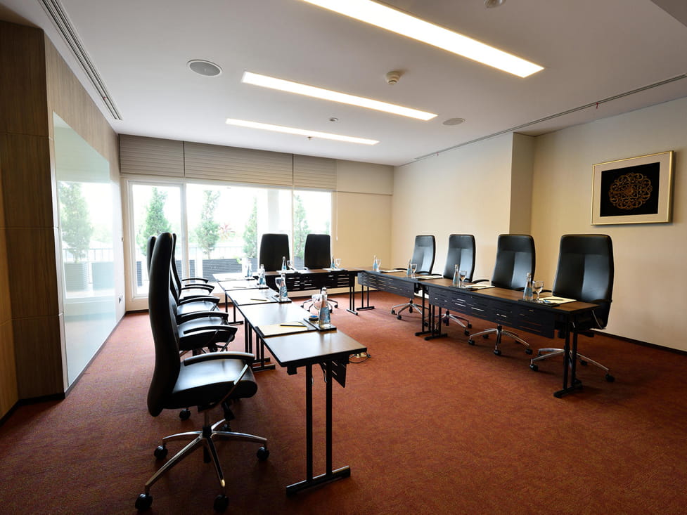 Gambar ruang konferensi hotel modern yang disiapkan untuk rapat bisnis.