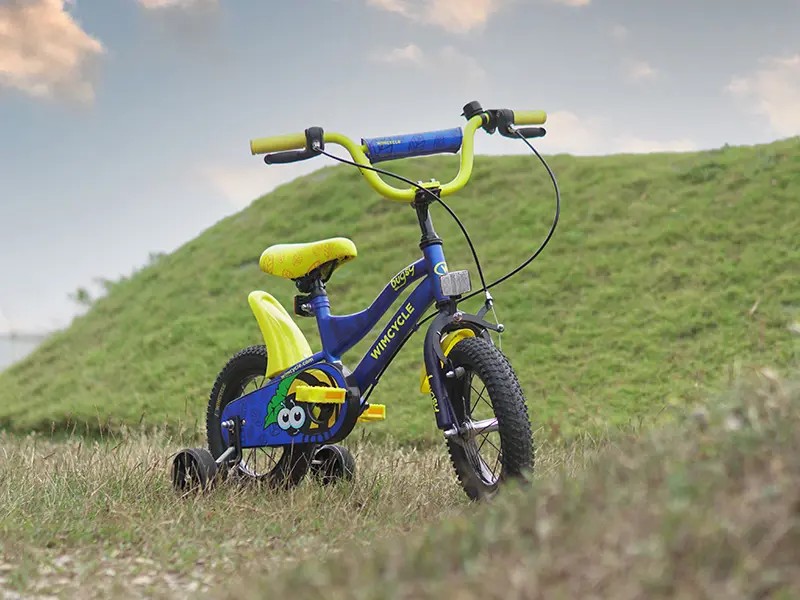 Gambar sepeda BMX Wimcycle Adrenaline dengan pengendara melakukan trik (misalnya, bunny hop) di taman skate atau lingkungan perkotaan, menonjolkan penggunaan dinamisnya, dengan latar belakang samar So