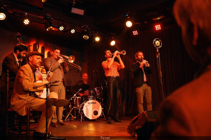 Panggung band dengan penyanyi di sebuah restoran live music yang ramai.