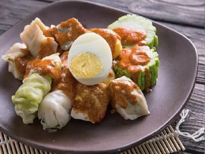 Semangkuk baso tahu dan siomay dengan siraman bumbu kacang dan perasan jeruk limau.