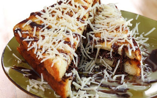 Sepiring roti bakar dengan topping keju dan cokelat leleh.