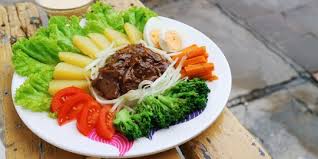 Seporsi nasi bistik dengan potongan daging dan saus khas di piring.