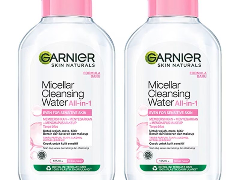 Gambar botol Garnier Micellar Cleansing Water for Normal & Dry Skin (tutup pink) dengan estetika segar dan bersih, menonjolkan sifat melembapkannya untuk kulit normal hingga kering, dengan latar b