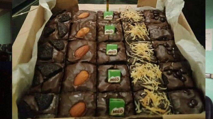 Berbagai jenis brownies dan kue tersusun rapi di etalase toko oleh-oleh yang modern.
