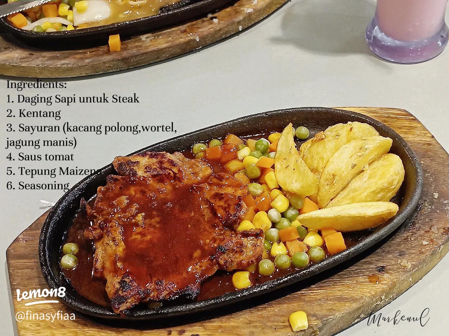 Piring berisi potongan steak medium rare dengan sayuran dan saus.