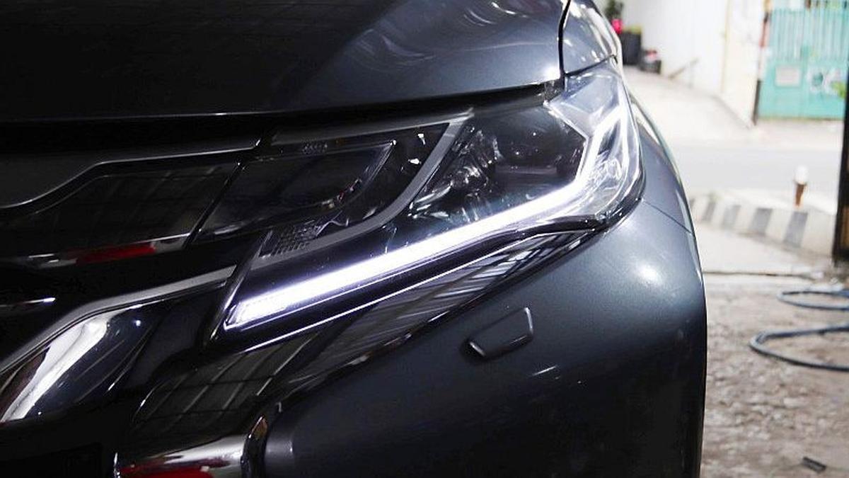 Headlamp mobil yang telah dimodifikasi dengan lampu LED DRL yang menyala terang dan desain modern.